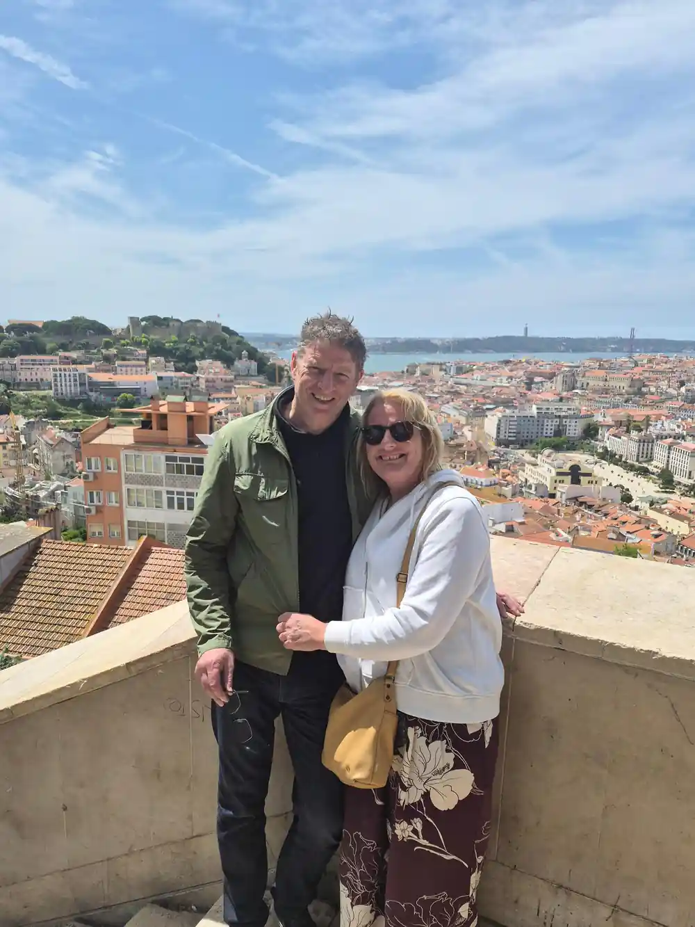 A couple at a viewpoint above the roofs with the castle behind
