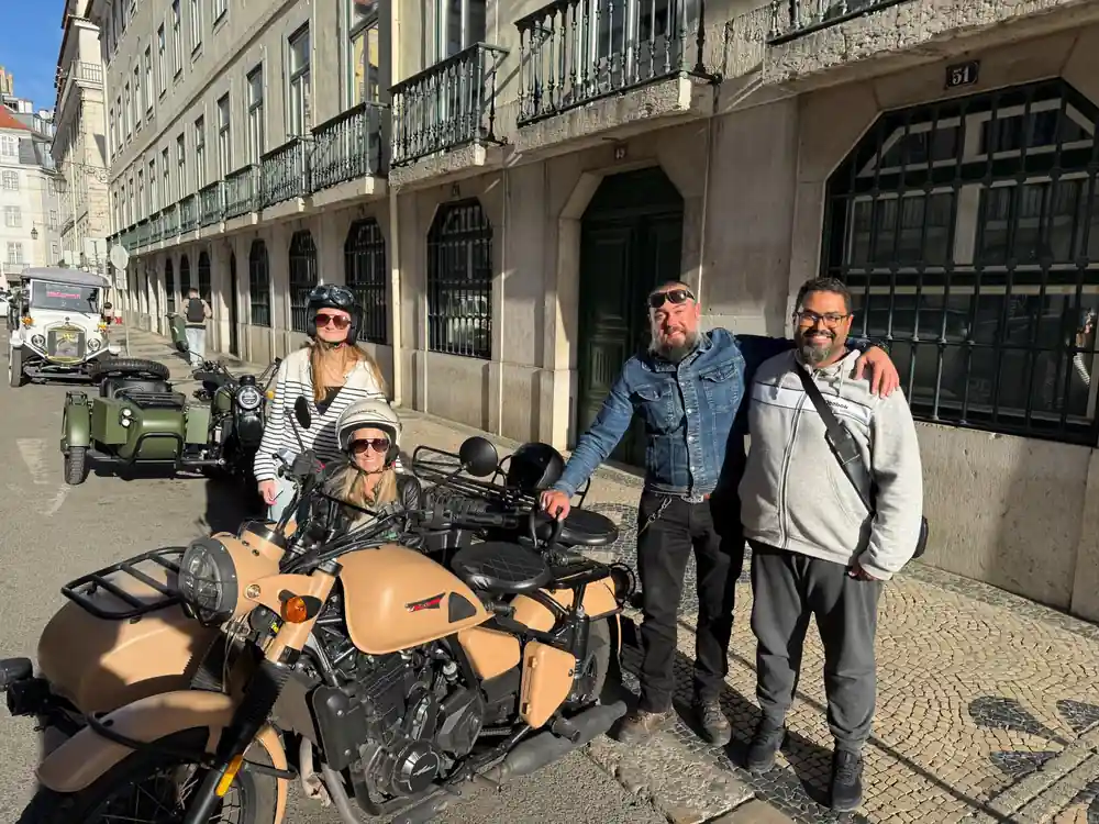 Four people with a tan sidecar in an arcaded street