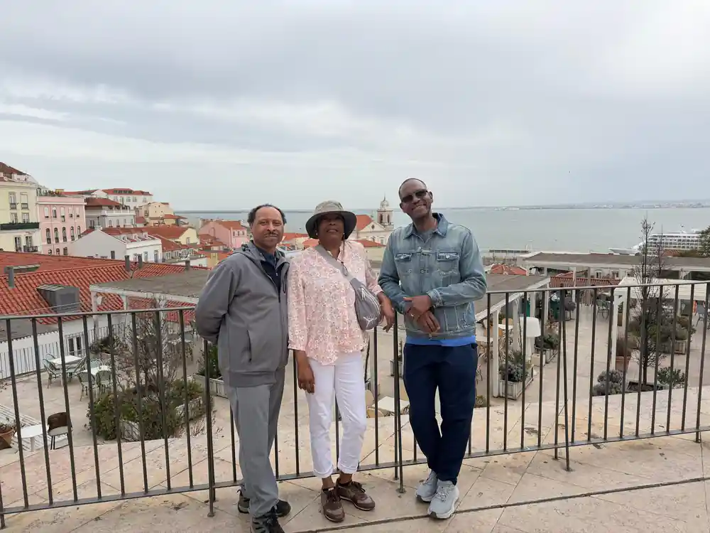 Three people at a viewpoint railing high above the river