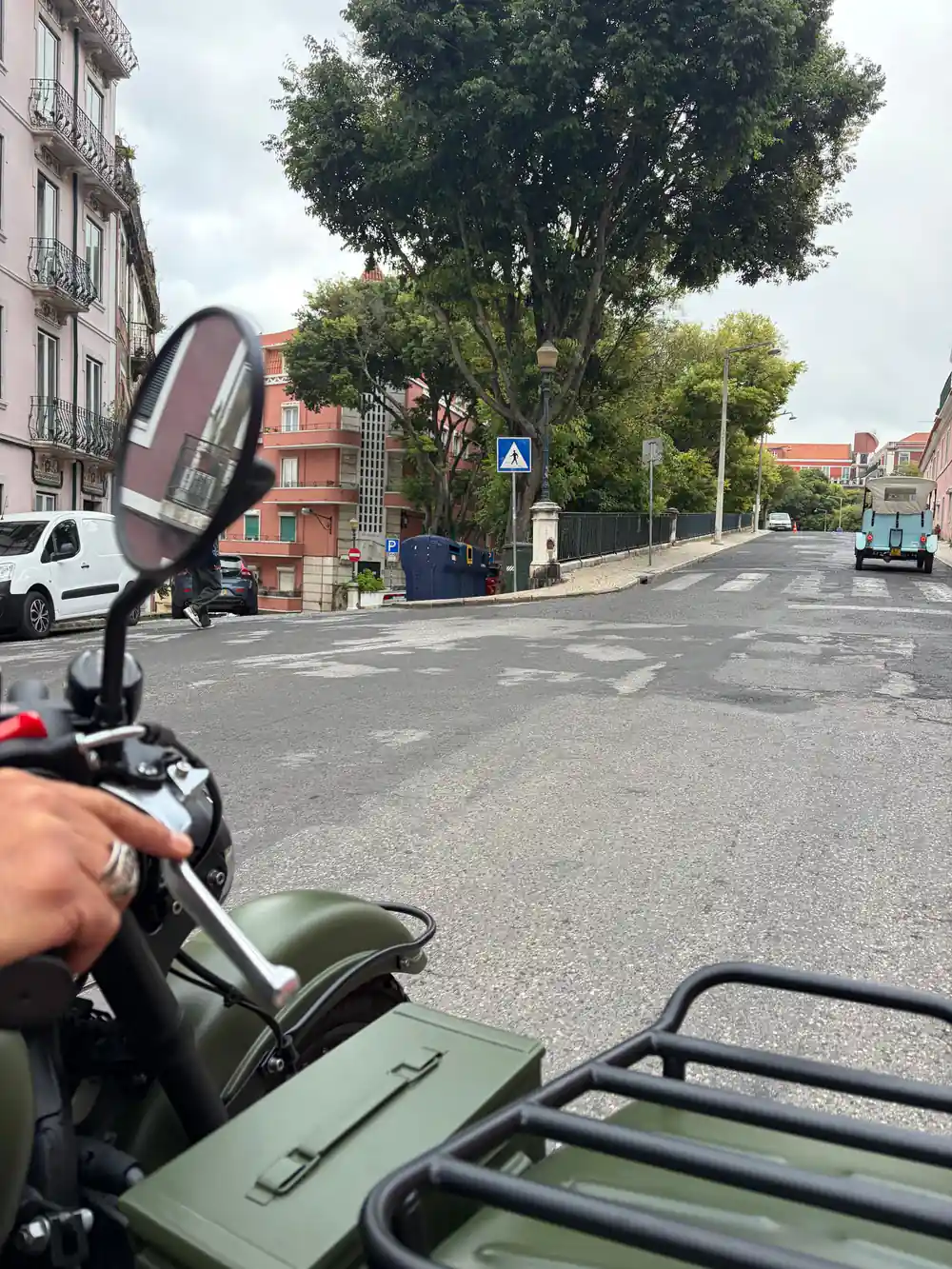 The view forward over the handlebars of an olive sidecar on an empty road